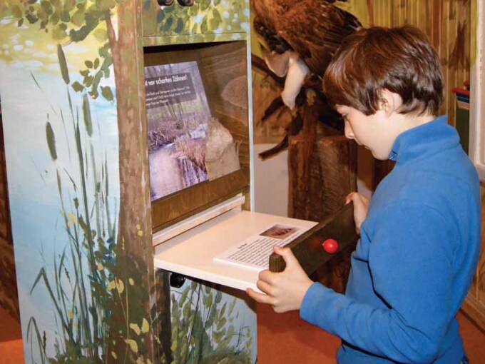 Kind liest eine Informationstafel