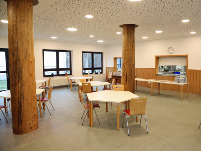 Speiseraum mit Stühlen, Tischen und der Essenausgabe